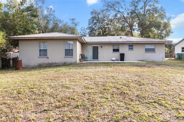 back of property featuring a lawn and a patio