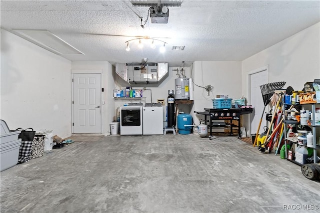 garage with a garage door opener, electric water heater, and washer and clothes dryer