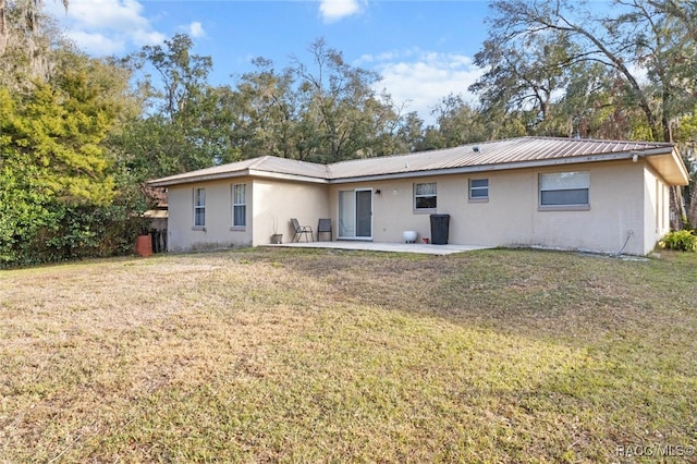 back of property featuring a patio and a lawn