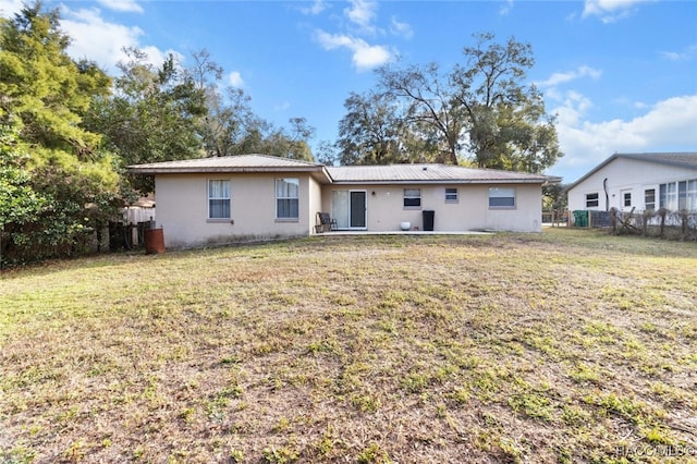 back of property featuring a lawn