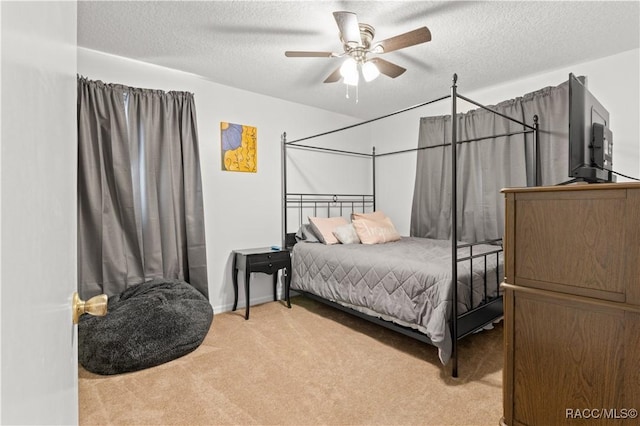 bedroom featuring ceiling fan, light colored carpet, and a textured ceiling