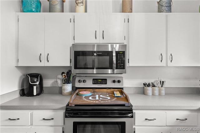 kitchen featuring stainless steel appliances and white cabinetry