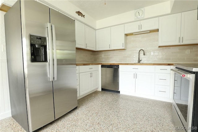 kitchen featuring butcher block counters, white cabinets, backsplash, and stainless steel appliances