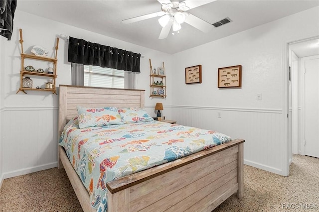 bedroom with visible vents, ceiling fan, and wainscoting