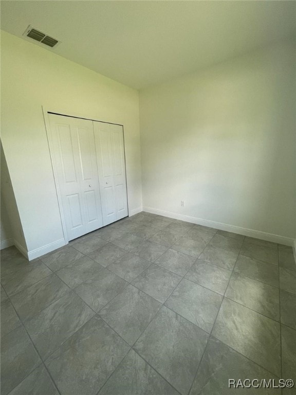 1569 W Mcneal Dr, Citrus Springs, FL 34434 - unfurnished bedroom with baseboards and a closet