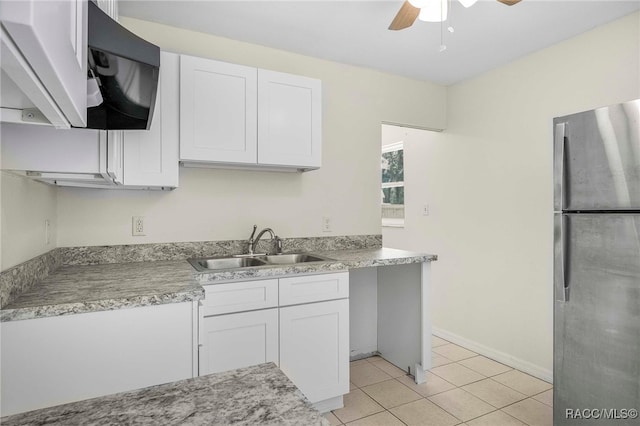 3410 N Bay Ave, Crystal River, FL 34428 - kitchen featuring freestanding refrigerator, a ceiling fan, white cabinetry, light tile patterned flooring, and light countertops