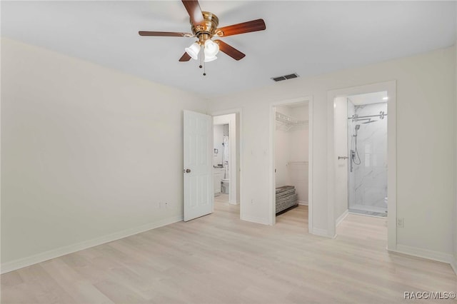 3410 N Bay Ave, Crystal River, FL 34428 - unfurnished bedroom featuring light wood-type flooring, a spacious closet, a closet, and ensuite bath