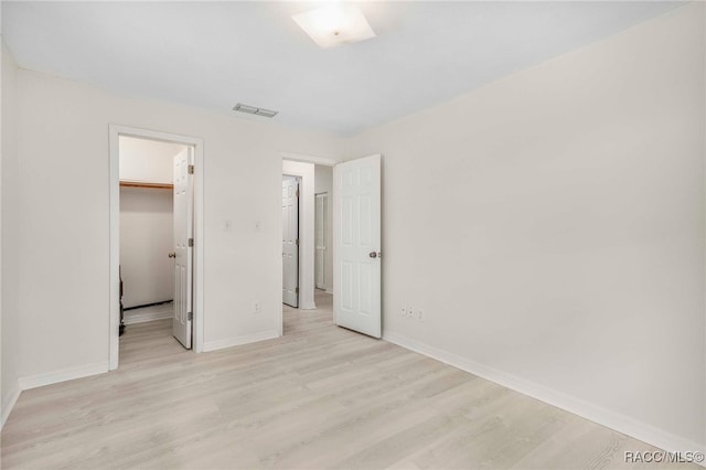 3410 N Bay Ave, Crystal River, FL 34428 - unfurnished bedroom with light wood-style floors, a spacious closet, and a closet