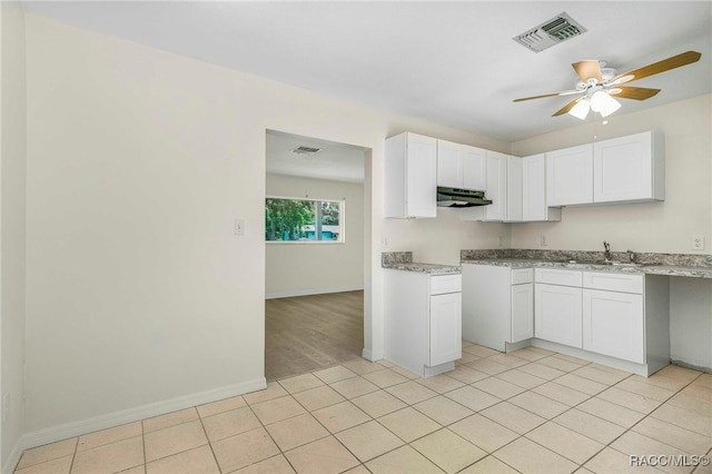 3410 N Bay Ave, Crystal River, FL 34428 - kitchen featuring under cabinet range hood, a ceiling fan, white cabinetry, light stone countertops, and light tile patterned floors