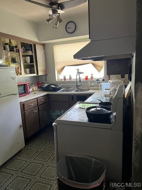 kitchen with ceiling fan, white refrigerator, dark brown cabinets, and sink