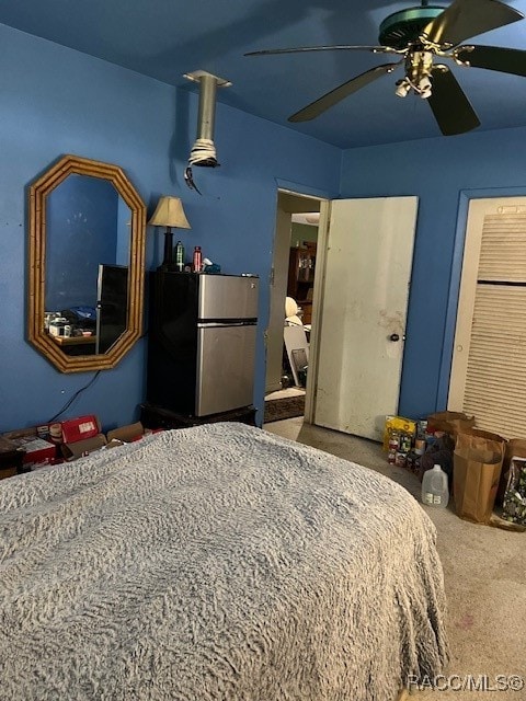 bedroom featuring carpet floors, a closet, stainless steel refrigerator, and ceiling fan