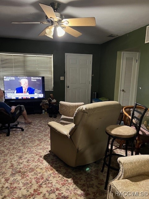 carpeted living room with ceiling fan