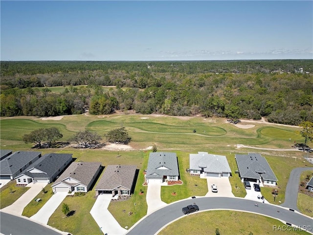 birds eye view of property with view of golf course, a wooded view, and a residential view