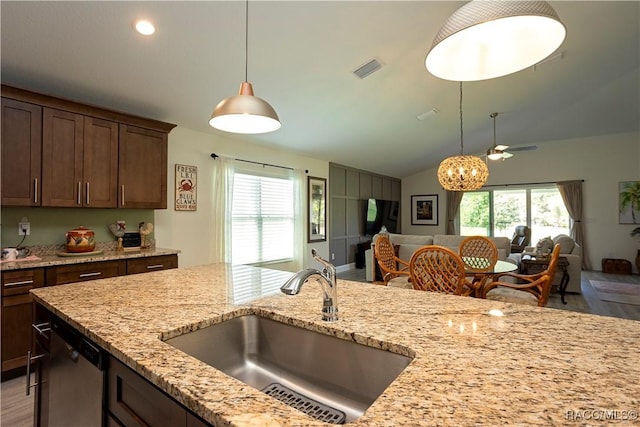 kitchen with open floor plan, plenty of natural light, stainless steel dishwasher, and a sink