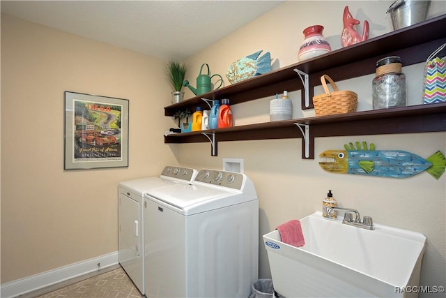 laundry room featuring a sink, baseboards, laundry area, and washer and dryer