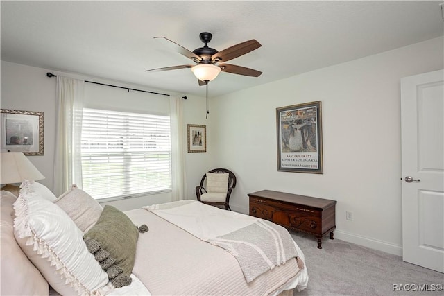 bedroom featuring a ceiling fan, light colored carpet, and baseboards