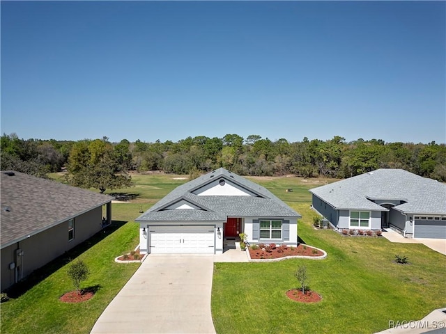 view of front of house featuring a front yard, a garage, driveway, and a shingled roof