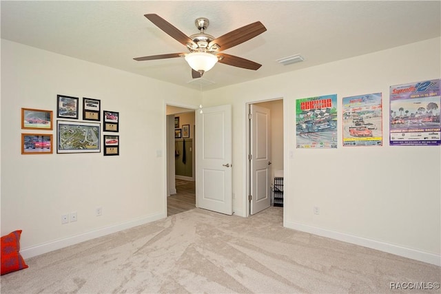 unfurnished bedroom featuring visible vents, baseboards, carpet, and a ceiling fan