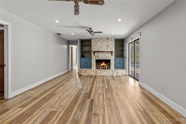96 N Fresno Ave, Hernando, FL 34442 - unfurnished living room with ceiling fan, light wood-style floors, a textured ceiling, built in shelves, and a fireplace