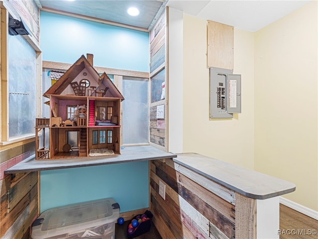 home office featuring electric panel and hardwood / wood-style flooring