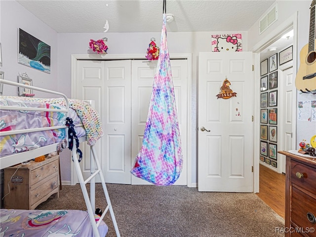 bedroom with carpet flooring, a textured ceiling, and a closet