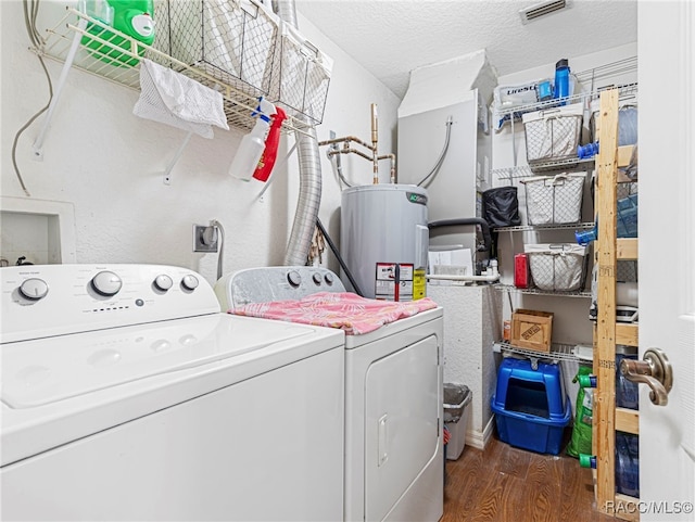 laundry area featuring washing machine and dryer, electric water heater, a textured ceiling, and dark hardwood / wood-style floors