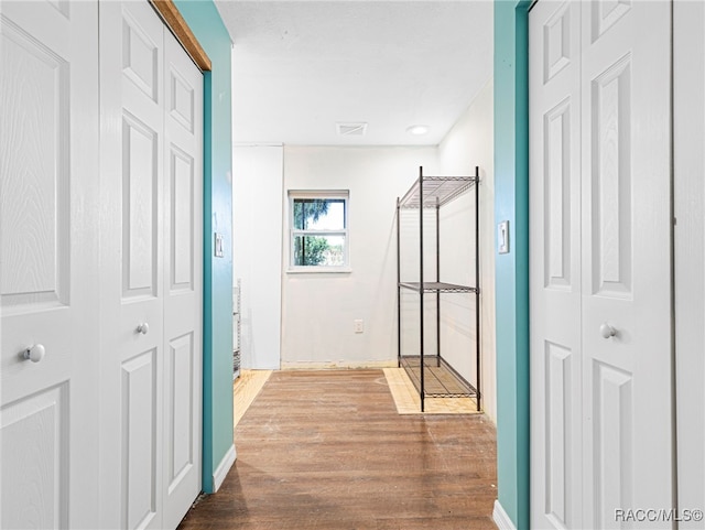 hallway with hardwood / wood-style flooring