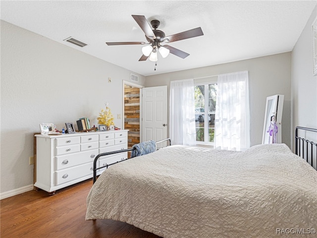 bedroom with hardwood / wood-style floors, a textured ceiling, and ceiling fan