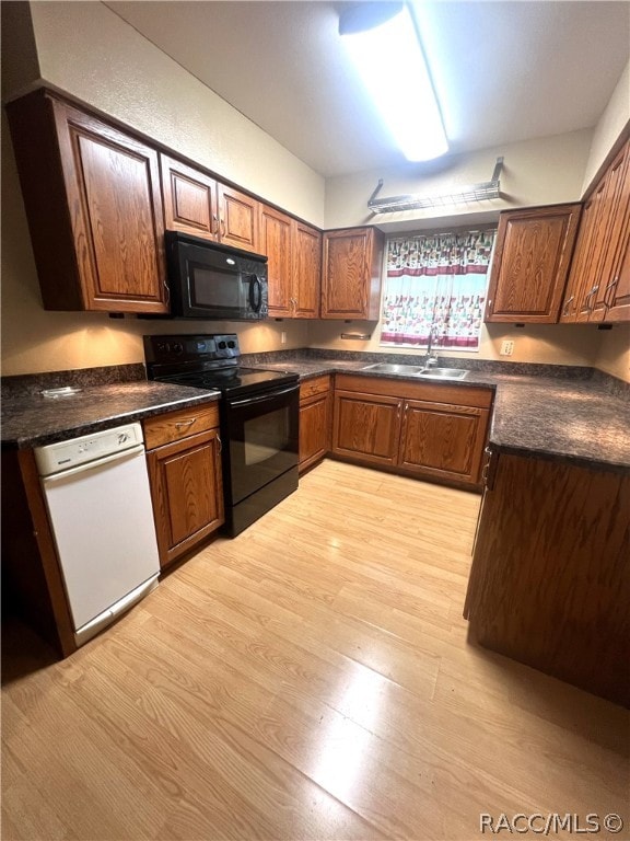 kitchen featuring sink, light hardwood / wood-style floors, and black appliances