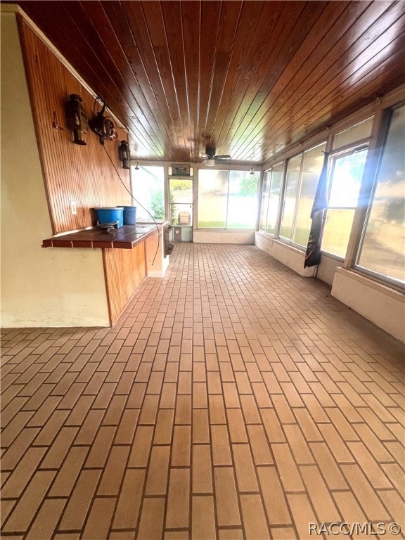 unfurnished sunroom with plenty of natural light and wooden ceiling