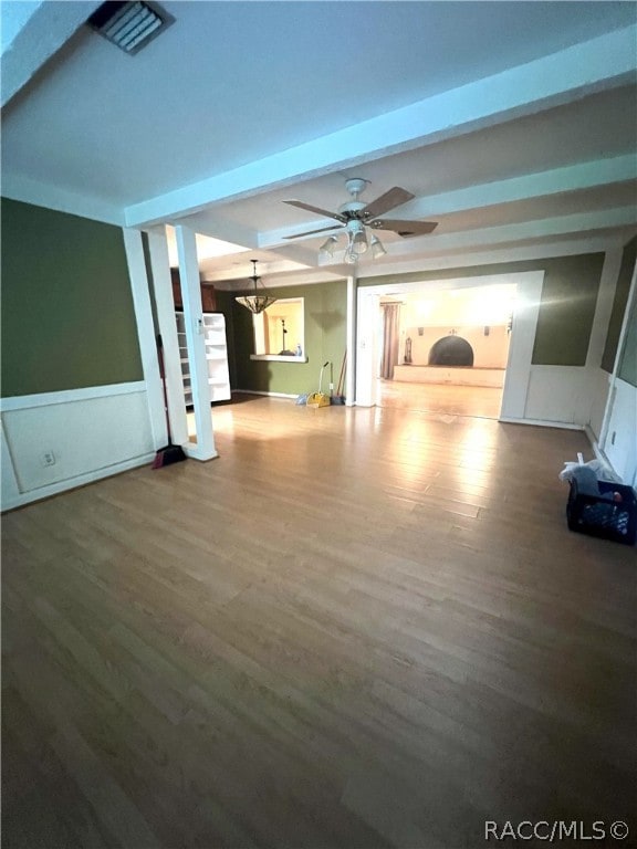 unfurnished living room with hardwood / wood-style flooring, ceiling fan with notable chandelier, and beam ceiling