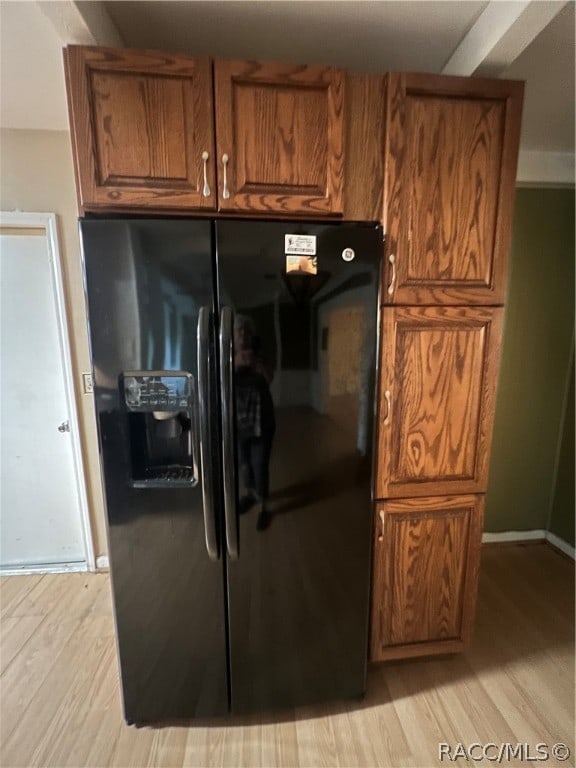 kitchen featuring light hardwood / wood-style flooring and black fridge