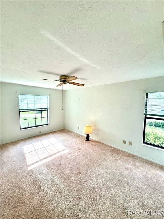 carpeted empty room with a textured ceiling and ceiling fan