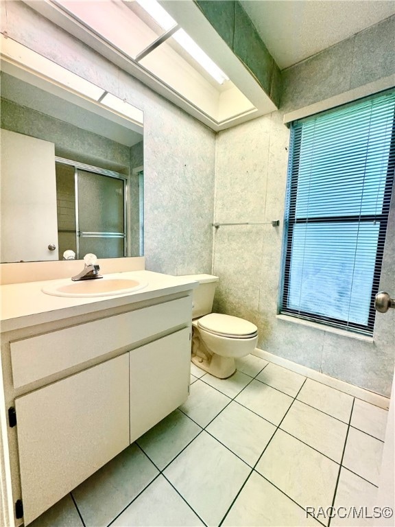 bathroom with tile patterned flooring, vanity, and toilet