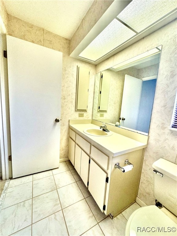 bathroom with tile patterned flooring, vanity, and toilet