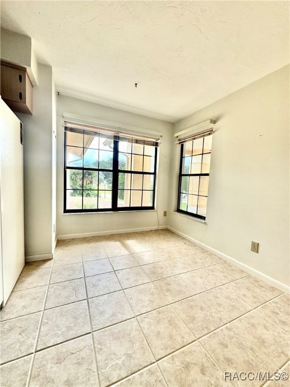 interior space with light tile patterned floors and a textured ceiling