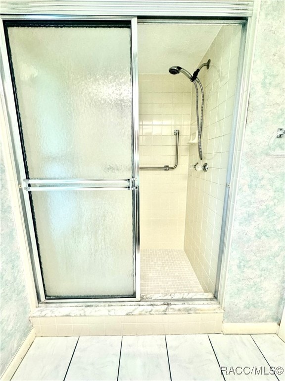 bathroom with tile patterned floors and a shower with shower door