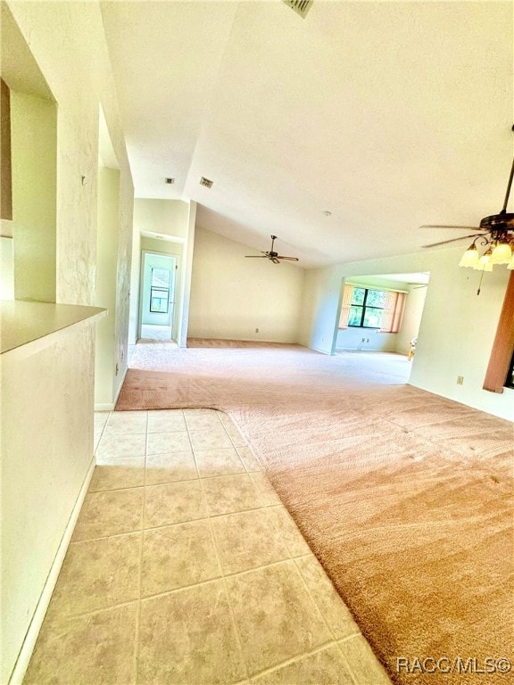 unfurnished living room with lofted ceiling and light carpet