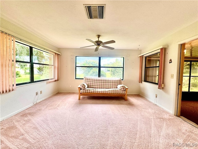 unfurnished bedroom featuring ceiling fan, light colored carpet, and a textured ceiling