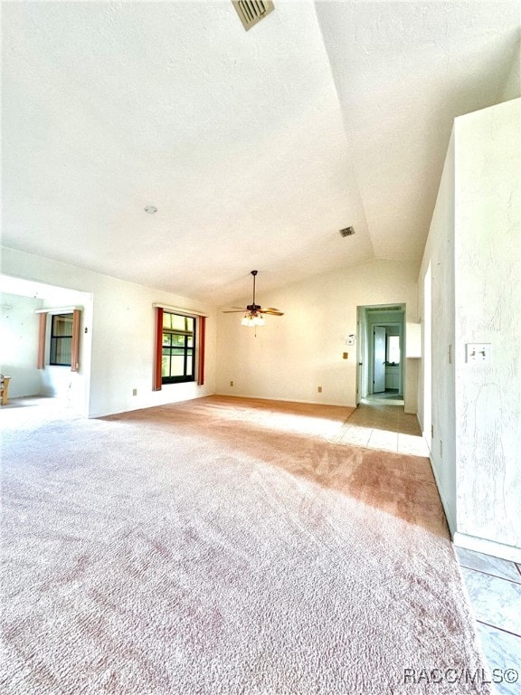 unfurnished living room featuring a textured ceiling, ceiling fan, light carpet, and vaulted ceiling