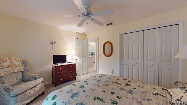 bedroom with ceiling fan, light colored carpet, and a closet