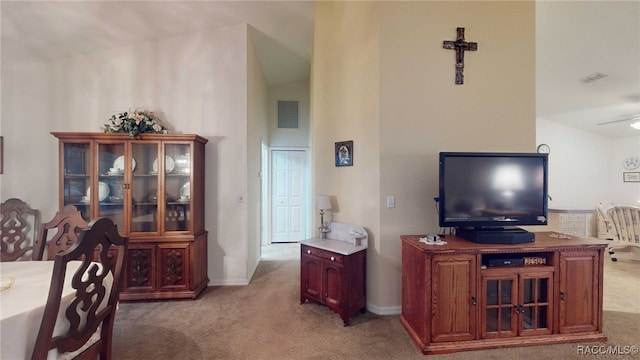 dining space with vaulted ceiling, ceiling fan, and light colored carpet