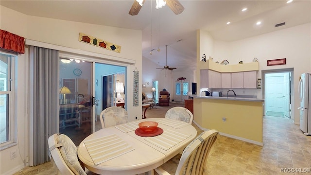 dining area with ceiling fan, sink, and high vaulted ceiling