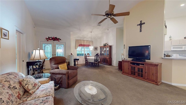 carpeted living room with ceiling fan and french doors