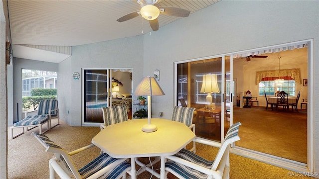 carpeted dining area featuring vaulted ceiling and ceiling fan