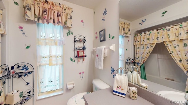 bathroom featuring a wealth of natural light and toilet