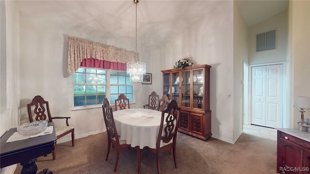 dining room featuring an inviting chandelier, carpet flooring, and a high ceiling