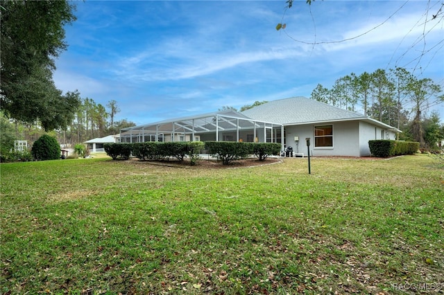 back of property with a yard and glass enclosure