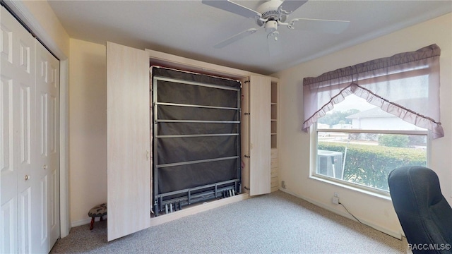 carpeted home office featuring ceiling fan