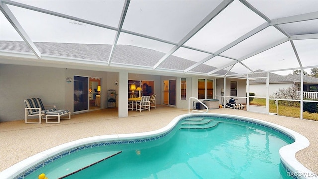 view of swimming pool featuring a patio area and glass enclosure